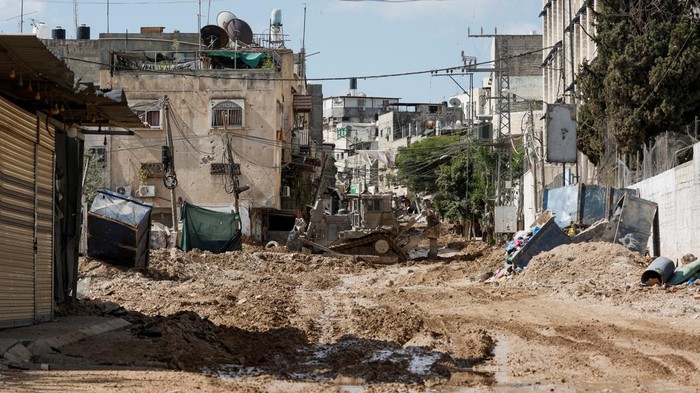 Members of the Palestine Red Crescent Society drive next to an Israeli military vehicle during an Israeli raid in Tulkarm, in the Israeli-occupied West Bank, September 12, 2024. REUTERS/Mohamad Torokman