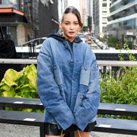 Enzy Storia mengenakan tank top hitam dengan luaran berupa jaket oversized berbahan denim, serta rok mini kulit. Padanan busananya memberi kesan bold, edgy dan androgini. Foto: dok. Coach