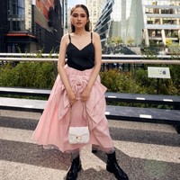 Syifa Hadju memadukan gaya edgy dan feminin dengan atasan hitam minimalis yang dipadankan rok pink beraksen pita besar. Tampilannya bold dengan sentuhan girly nan manis. Foto: dok. Coach