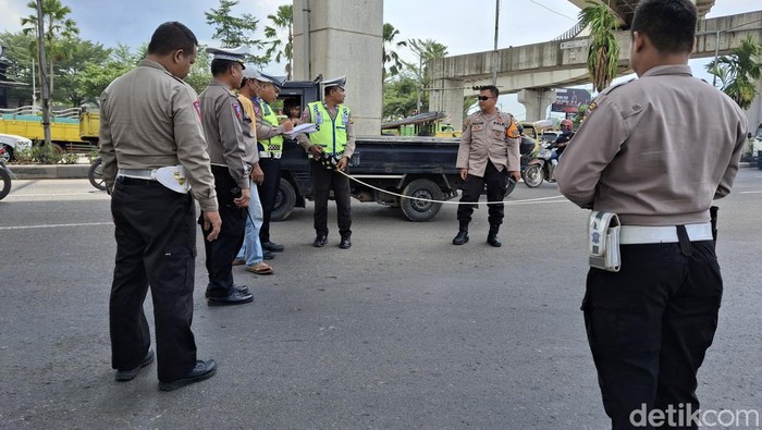 Polisi melakukan olah tkp pemotor tewas terserempet truk.