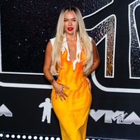 Karol G mungkin berniat ‘membakar’ red carpet dengan gaun bertema api dari koleksi vintage Véronique Leroy yang pernah rilis pada 1993. Penampilannya sukses mencuri perhatian, tapi juga terlihat kuno dan warnanya tidak cocok untuknya. Foto: Gotham/WireImage