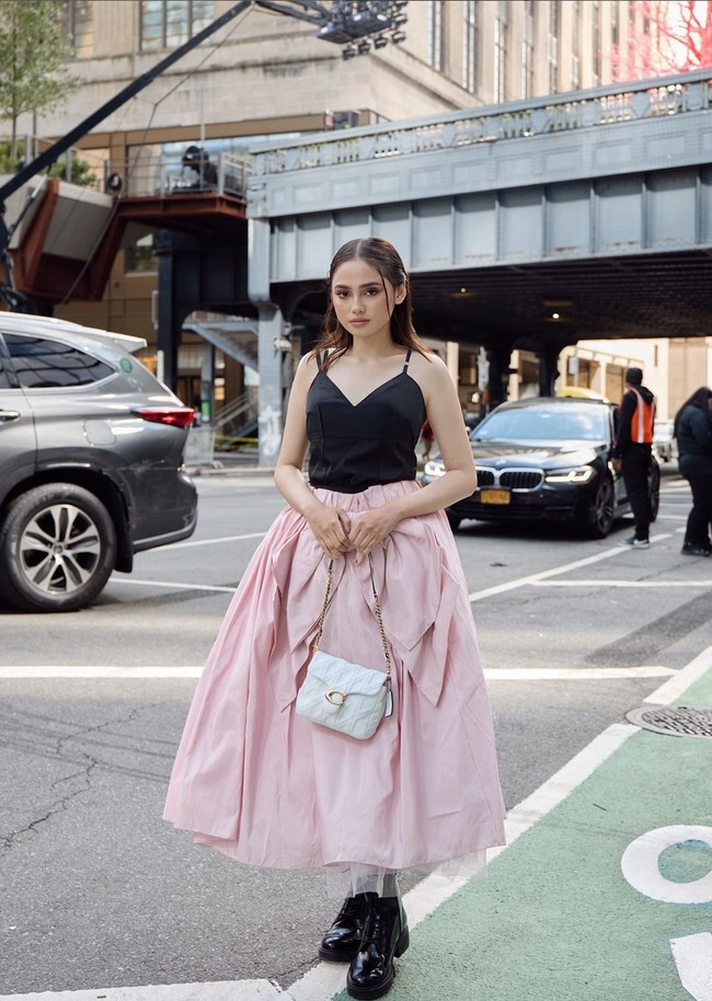 Syifa melengkapi busananya dengan sepatu boots yang sleek dan tas Coach Times Square Tabby putih ikonik beraksen rantai emas. Foto: Instagram/@syifahadju