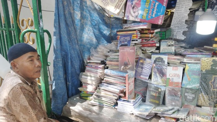 Aslah di depan lapak bukunya.