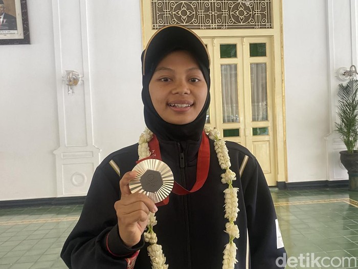 Atlet para badminton asal Kulon Progo, Qonitah Ikhtiar Syakuroh, memamerkan medali perak dari Paralimpiade Paris 2024 di Kompleks Kepatihan, Kota Jogja, Jumat (13/9/2024).