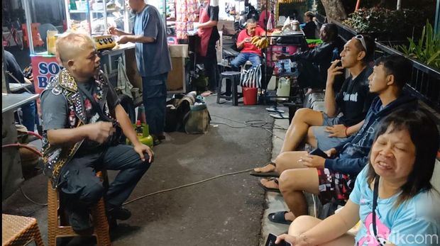 Tutung penjual mi ayam yang berpenampilan punk saat melayani pembeli di Alun-alun Purwokerto, Kamis (12/9/2024) malam.