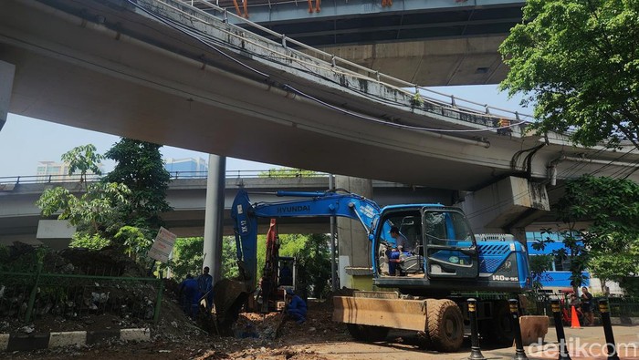Sejumlah petugas memasang beton drainase ke dalam lubang di Kebayoran Lama, Jakarta Selatan, Jumat (13/9/2024).