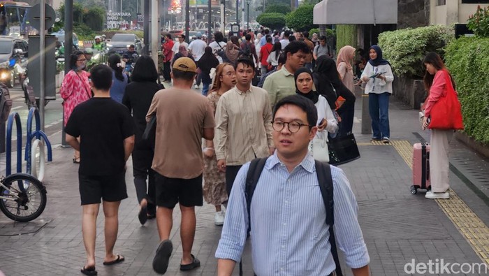 Para karyawan bergegas pulang di kawasan pelican crossing Jl MH Thamrin, Jakarta, Jumat (13/9/2024).
