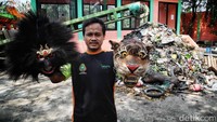 Bangkit menunjukkan dua topeng yang terbuat dari limbah kayu.