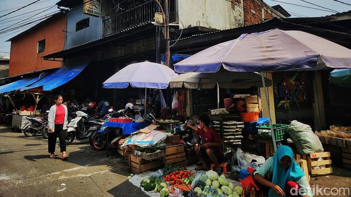 Wacana Membangun Permukiman di Atas Pasar Aktivitas jual beli barang kebutuhan pokok terlihat di Kawasan Pasar Kebayoran Lama, Jakarta Selatan, Jumat (13/9/2024). Tampak kepadatan lapak pedagang maupun ruko dengan latar belakang apartemen mewah. Pasangan calon Gubernur Ridwan Kamil-Suswono berencana membangun permukiman di atas pasar untuk mengurangi kekumuhan dan harga perumahan yang semakin mahal di tengah kota.