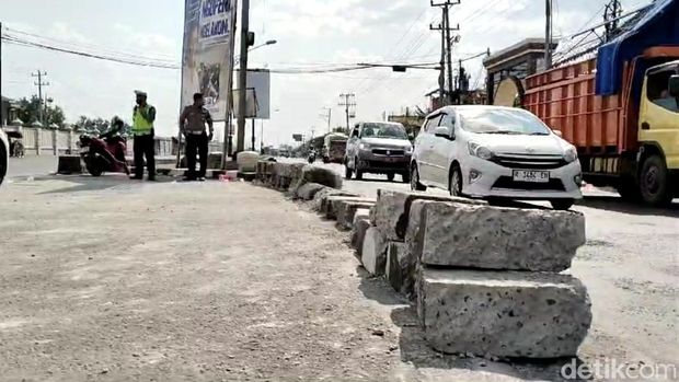 Warga membongkar beton pembatas jalan di simpang tiga Pejagan, Brebes, Jumat (13/9/2024).