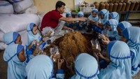 Pembudidaya mengarahkan murid taman kanak - kanak (TK) membuat media tanam jamur.