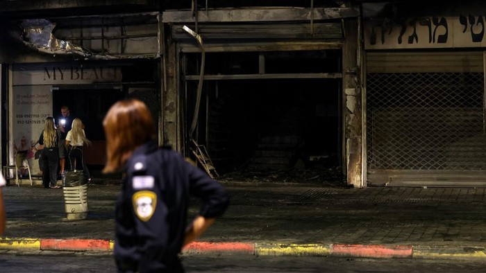 A member of the Israeli security forces stands at the scene where a vehicle exploded in the central Israeli city of Ramla on September 12, 2024, reportedly killing several people and injuring others. The spokesman for the Asaf Harofe Medical Center in central Israel, said it 