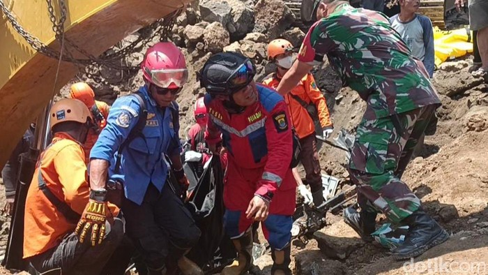 Petugas evakuasi operator alat berat yang tertimbun longsor