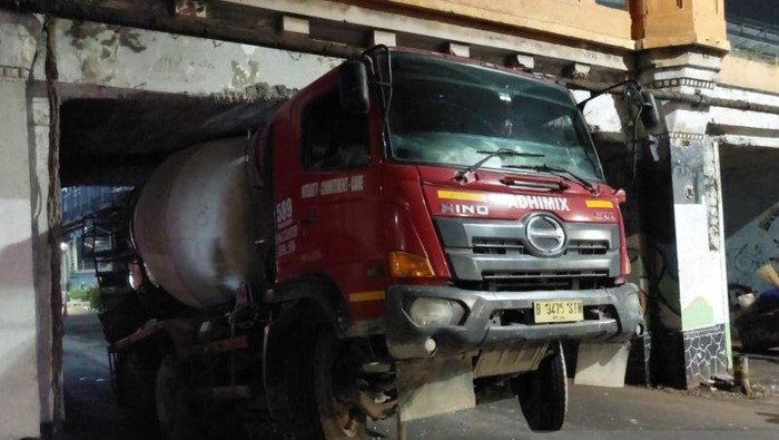 Sebuah truk molen bernomor polisi B 9475 SIN tersangkut di kolong jembatan perlintasan rel kereta di Jalan Matraman Raya, Jakarta Timur, Sabtu (14/9/2024) dini hari. ANTARA/Syaiful Hakim