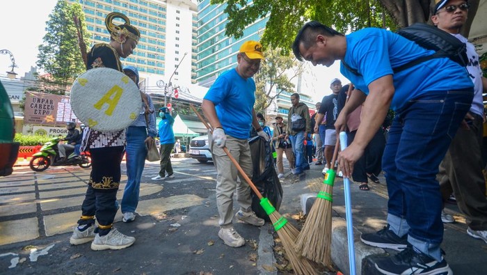 Kang Arfi saat aksi bersih-bersih usai pawai kendaraan hias di Kota Bandung.