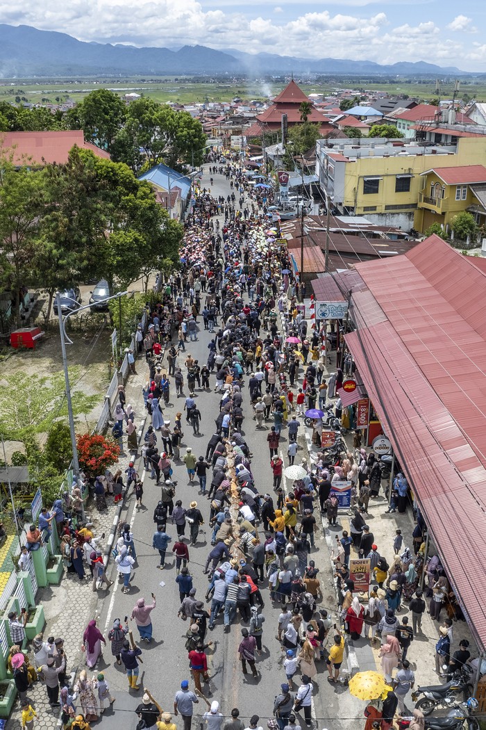 Foto udara sejumlah warga melaksanakan tradisi naheik pamau atau menarik balok secara bersama-sama di Jalan Jenderal Sudirman, Pondok Tinggi, Sungai Penuh, Jambi, Minggu (15/9/2024). Kegiatan yang diikuti seribu lebih warga untuk menyambut peringatan 150 tahun pendirian bangunan cagar budaya Masjid Agung Pondok Tinggi dalam rangkaian Festival Lek Nagroi Kenduri Swarnabhumi 2024 tersebut bertujuan menghidupkan kembali tradisi naheik pamau Pondok Tinggi yang telah punah sejak 50 tahun terakhir. ANTARA FOTO/Wahdi Septiawan/foc.