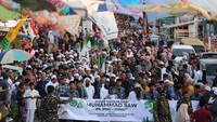 Peserta berjalan dan membaca shalawat saat mengikuti kirab Maulid Nabi di Kampung Nelayan Nambangan, Surabaya, Jawa Timur, Minggu (15/9/2024). 
