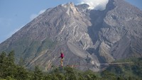 Wisatawan mancanegara berjalan di atas tali saat melakukan olahraga highline di lereng Gunung Merapi, Kalitalang, Balerante, Kemalang, Klaten, Jawa Tengah, Minggu (15/9/2024). 