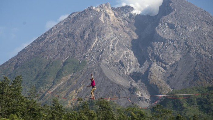 Wisatawan mancanegara berjalan di atas tali saat melakukan olahraga highline di lereng Gunung Merapi, Kalitalang, Balerante, Kemalang, Klaten, Jawa Tengah, Minggu (15/9/2024). Lokasi tebing pada lereng Gunung Merapi yang tinggi serta pemandangan yang indah menambah daya tarik dan tantangan untuk para pegiat melakukan olahraga ekstrem tersebut. ANTARA FOTO/Aloysius Jarot Nugroho/YU