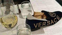 Makan di restoran bergaya fine dining, pengunjung ini disajikan roti di dalam sepatu Versace. Foto: pool/site