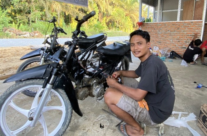 Aktivitas Zaid dalam menjalankan usaha bengkelnya sendiri di pelataran rumahnya di Pelalawan.