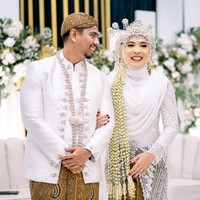 Fitri Tropica dan suami pun kembali bergaya bak pasangan pengantin. Keduanya kompak mengenakan busana pengantin adat Sunda berwarna putih. Foto: Instagram/@fitrop