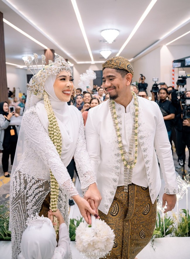 Seperti acara pernikahan pada umumnya, Fitri dan Irvan juga melakukan lempar bunga. Tampak keduanya yang begitu bahagia dan tersenyum memandang satu sama lain. Foto: Instagram/@fitrop