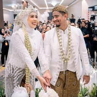 Seperti acara pernikahan pada umumnya, Fitri dan Irvan juga melakukan lempar bunga. Tampak keduanya yang begitu bahagia dan tersenyum memandang satu sama lain. Foto: Instagram/@fitrop