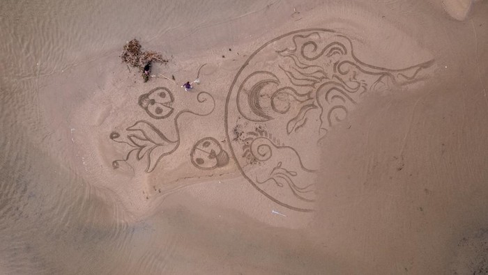 A drone view shows artist Nikola Faler working on sand drawing in the mouth of the river Neretva during the 4th Sand Art Festival near Ploce, Croatia, September 14, 2024. REUTERS/Antonio Bronic     TPX IMAGES OF THE DAY