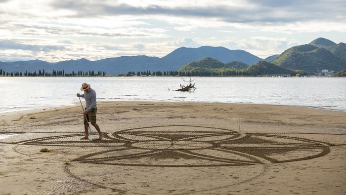 A drone view shows artist Nikola Faler working on sand drawing in the mouth of the river Neretva during the 4th Sand Art Festival near Ploce, Croatia, September 14, 2024. REUTERS/Antonio Bronic     TPX IMAGES OF THE DAY