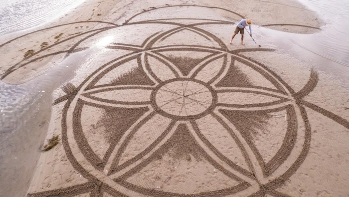 A drone view shows artist Nikola Faler working on sand drawing in the mouth of the river Neretva during the 4th Sand Art Festival near Ploce, Croatia, September 14, 2024. REUTERS/Antonio Bronic     TPX IMAGES OF THE DAY
