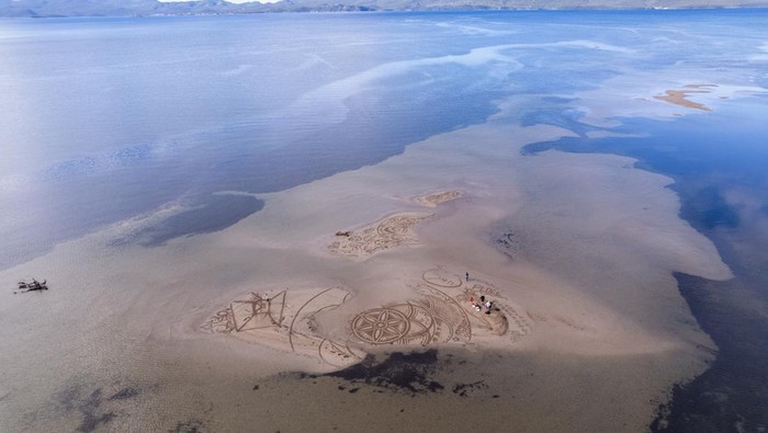A drone view shows artist Nikola Faler working on sand drawing in the mouth of the river Neretva during the 4th Sand Art Festival near Ploce, Croatia, September 14, 2024. REUTERS/Antonio Bronic     TPX IMAGES OF THE DAY