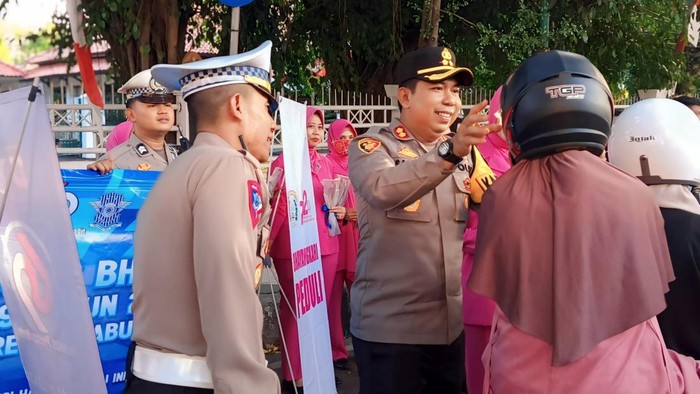 Polisi berikan helm gratis ke pemotor.
