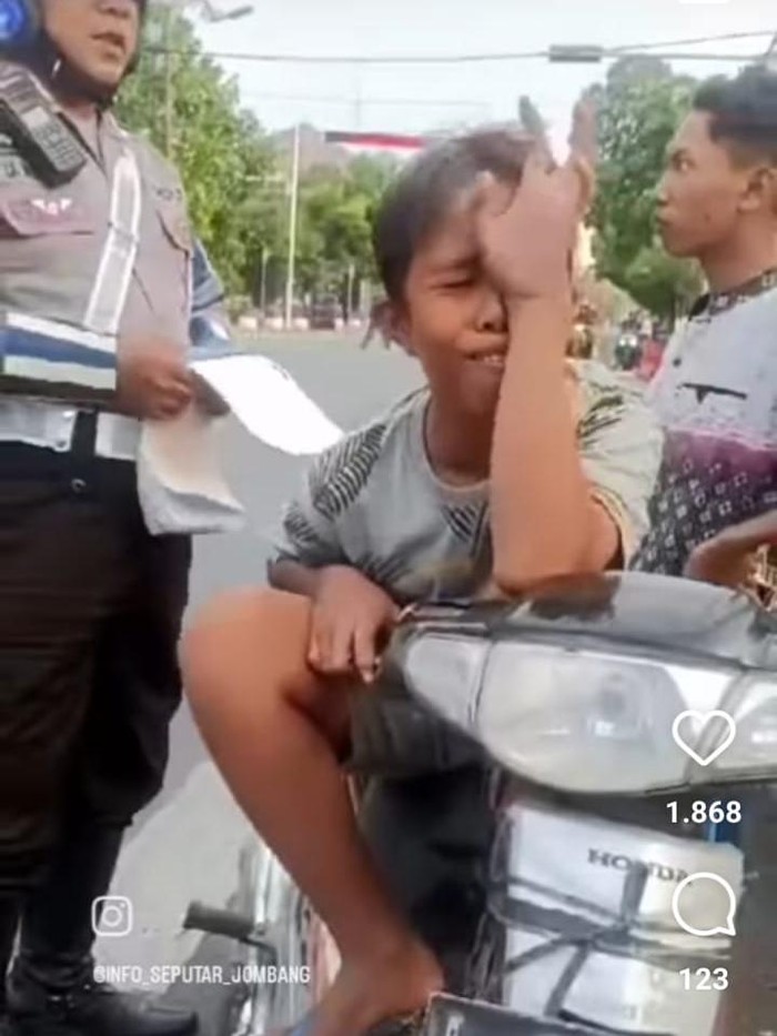 Anak yang berboncengan naik motor tanpa helm menangis saat disetop polisi.