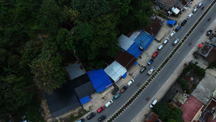 Antrean kendaraan di SPBU Kendari Foto udara puluhan unit kendaraan roda dua dan empat mengantre untuk mendapatkan BBM Pertalite di SPBU 74.931.12 di Kecamatan Baruga, Kendari, Sulawesi Tenggara, Selasa (17/9/2024). Antrean kendaraan terjadi di seluruh SPBU di Kendari dalam dua pekan terakhir akibat kekhawatiran warga kehabisan BBM tersebut sehingga pihak PT Pertamina telah menambah stok sebesar 129 persen dari alokasi rata-rata normal atau 584 kilo liter per hari pada September 2024. ANTARA FOTO/Jojon/nym.