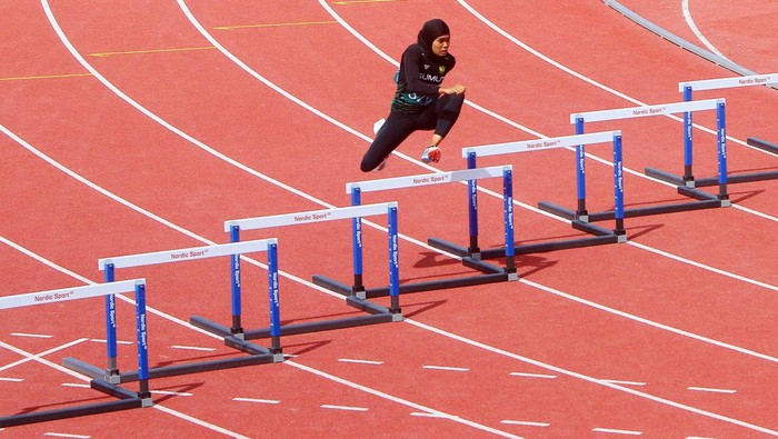 Atlet lari Sumatera Utara, Nella Agustin melompati gawang pada nomor lari gawang 400 meter putri  cabang atletik PON  Aceh- Sumut di Stadion Madya Sena, Deli Serdang, Sumatera Utara, Senin (16/9).  Pelari Sumut Nella Agustin meraih medali emas sekaligus memecahkan rekor PON dengan catatan waktu 58,3 detik. PB PON XXI/ Rahmad Suryadi