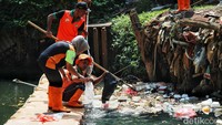 Petugas mengumpulkan sampah plastik yang mengapung di sungai kawasan Pasar Rebo.  