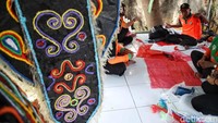 Para petugas Unit Penanganan Sampah Badan Air Dinas Lingkungan Hidup Pasar Rebo melakukan pembuatan baju adat dari sampah plastik.  