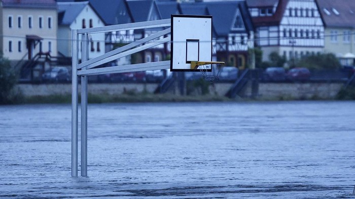 A basketball hoop stands in the flood waters of the Elbe in Bad Schandau, Germany Monday, Sept. 16, 2024. (Jan Woitas/dpa via AP)