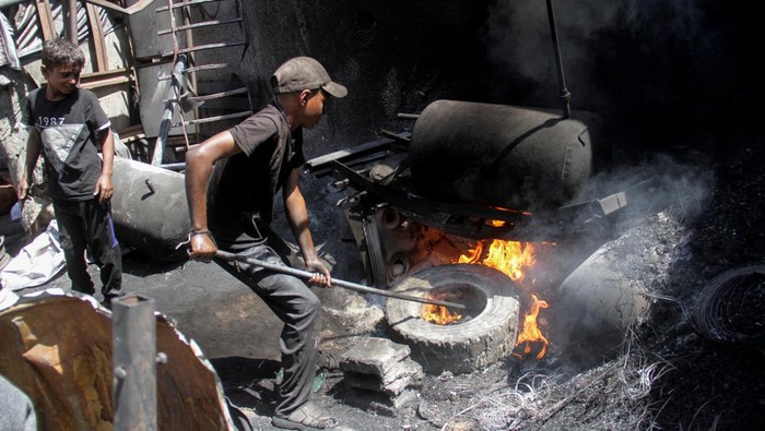 Potret Warga Gaza Ubah Sampah Plastik Jadi Bahan Bakar di Tengah Kelangkaan A Palestinian burns plastic waste to produce alternative fuel amid scarcity as the Israel-Hamas conflict continues, in northern Gaza Strip, September 5, 2024. REUTERS/Mahmoud Issa