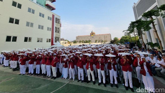 Ribuan mahasiswa UM Surabaya baru memberikan pesan harapan dan kritik yang ditulis di payung