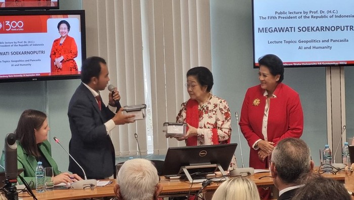 Seorang ilmuwan asal Indonesia, Gerry Utama, memberikan cendera mata berupa sampel batuan Antartika ke Ketua Umum PDIP Megawati Soekarnoputri saat kuliah umum di St Petersburg State University, Rusia.  (Haris-detikcom)