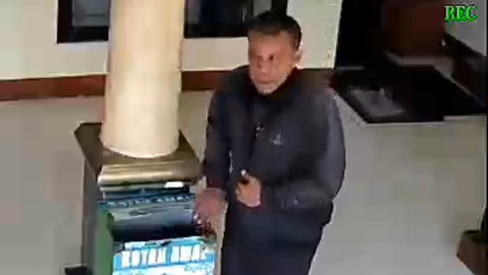 Seorang pria terekam kamera tengah melakukan pencurian dengan cara membobol kotak amal di sebuah musala di Pondok Aren, Tangerang Selatan. Foto: tangkapan layar video viral