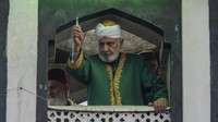 Seorang ulama memamerkan benda yang diyakini sebagai sehelai rambut dari jenggot Nabi Muhammad.