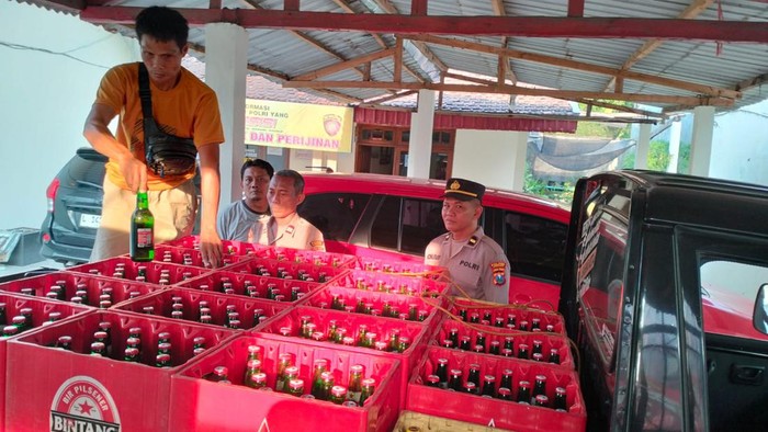 Wahab dan miras-miras yang hendak dikirim ke Jombang di kantor polisi