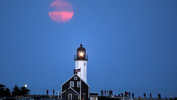 Supermoon Panen terlihat muncul indah di atas mercusuar ikonis di Scituate, Massachusetts, AS, 17 September 2024. REUTERS/Lauren Owens