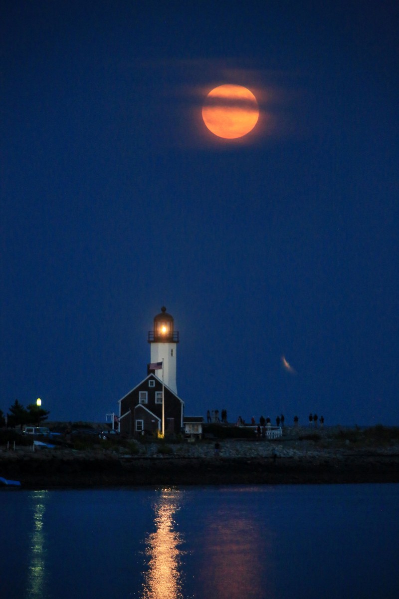 Supermoon Panen terlihat muncul indah di atas mercusuar ikonis di Scituate, Massachusetts, AS, 17 September 2024. REUTERS/Lauren Owens