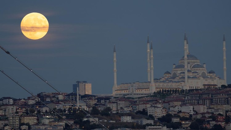 8 Potret Keindahan Bulan Purnama di Berbagai Negara Bulan terbit dengan indah di atas Bukit Camlica yang terkenal di Istanbul, Turki, pada 17 September 2024. REUTERS/Murad Sezer