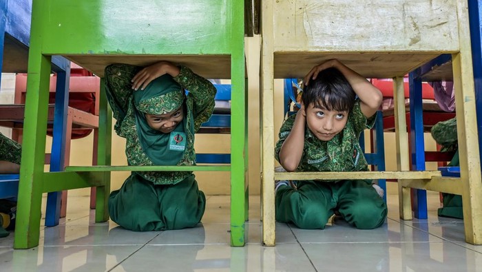 Antusias Anak SD di NTB Ikut Simulasi Mitigasi Gempa Petugas mengajarkan tata cara melindungi kepala dengan tangan kepada siswa-siswi saat simulasi mitigasi gempa bumi dan kebakaran di Sekolah Dasar Al Iqra, Mataram, Nusa Tenggara Barat, Rabu (18/9/2024). Simulasi mitigasi bencana gempa bumi yang diselenggarakan oleh You N Me Foundation tersebut sebagai upaya menyiapkan langkah antisipasi serta meningkatkan kesiapsiagaan dan kemampuan siswa maupun guru pada penanganan bencana gempa bumi. ANTARA FOTO/Ahmad Subaidi/agr