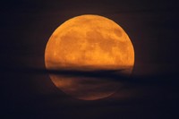 A supermoon rises behind clouds over Larnaca international airport in the eastern Mediterranean island of Cyprus, on Tuesday, Sept. 17, 2024. (AP Photo/Petros Karadjias)